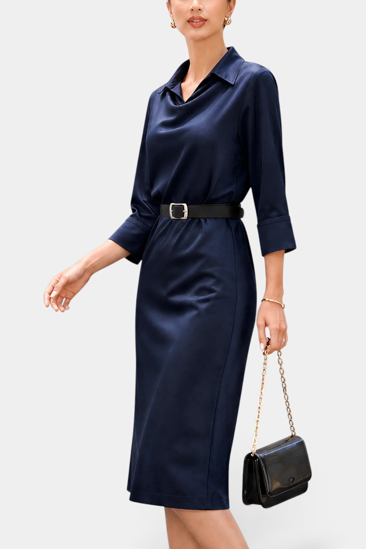 Mahaute Macarena midi dress in navy satin with a shirt collar, draped bodice, and a black belt with a square buckle.
