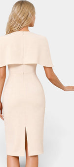 Robe mi-longue beige Mahaute Machteld avec cape, manches longues et boutons dorés, ajustée pour un style élégant.