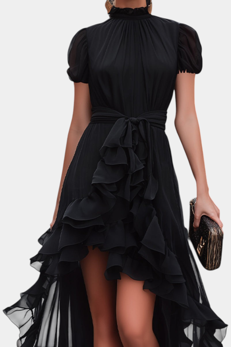 Mahaute Melusina black asymmetrical long dress with ruffled skirt, puffed sleeves, and a tied waist for evening wear.