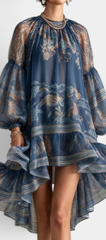 Robe courte asymétrique Mahaute Milagros en mousseline imprimée avec manches ballon et volants, détails floraux élégants.