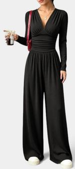 Mahaute Mirabel black long-sleeve jumpsuit with a V-neck, gathered bodice, cinched waist, and wide-leg trousers.