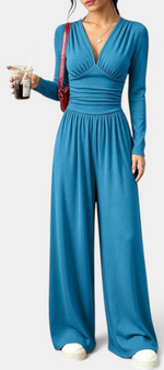 Mahaute Mirabel blue long-sleeve jumpsuit with V-neck, gathered waist, and wide-leg trousers on a model.