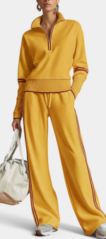 Mahaute mustard yellow knit set with zip-up collar, ribbed cuffs, and contrasting side stripes on wide-leg pants.