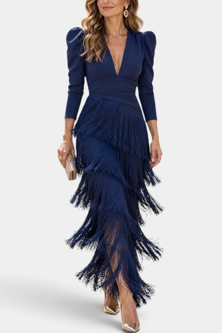 Mahaute navy blue long dress with layered fringe skirt, deep V-neckline, and structured puff sleeves on a model.