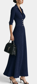 Mahaute Jessamine navy blue ribbed knit maxi dress with shirt collar, cinched waist, and gold buttons on a model.