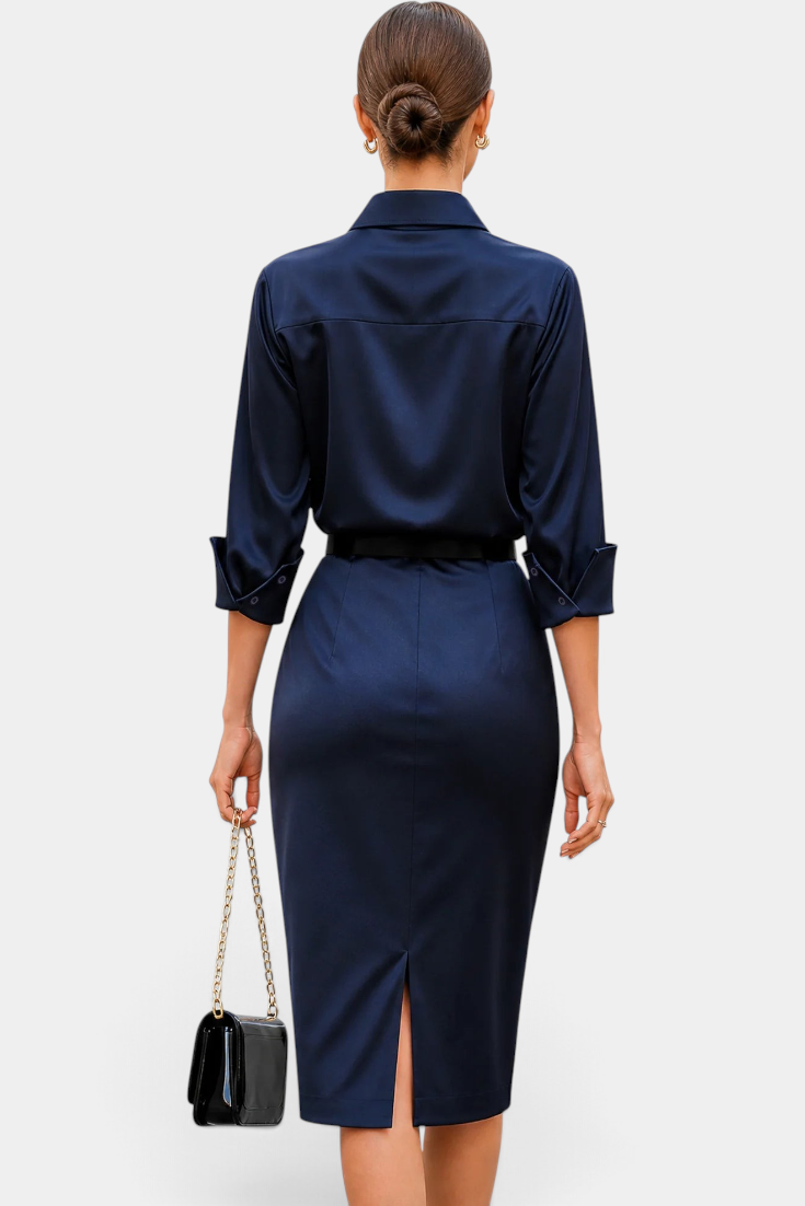 Back view of a woman wearing a Mahaute navy satin midi shirt dress with a belted waist and back slit