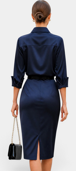 Back view of a woman wearing a Mahaute navy satin midi shirt dress with a belted waist and back slit