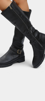 Mahaute Nevena black faux leather knee-high boots with a buckled ankle strap, side zipper, and chunky lug sole.