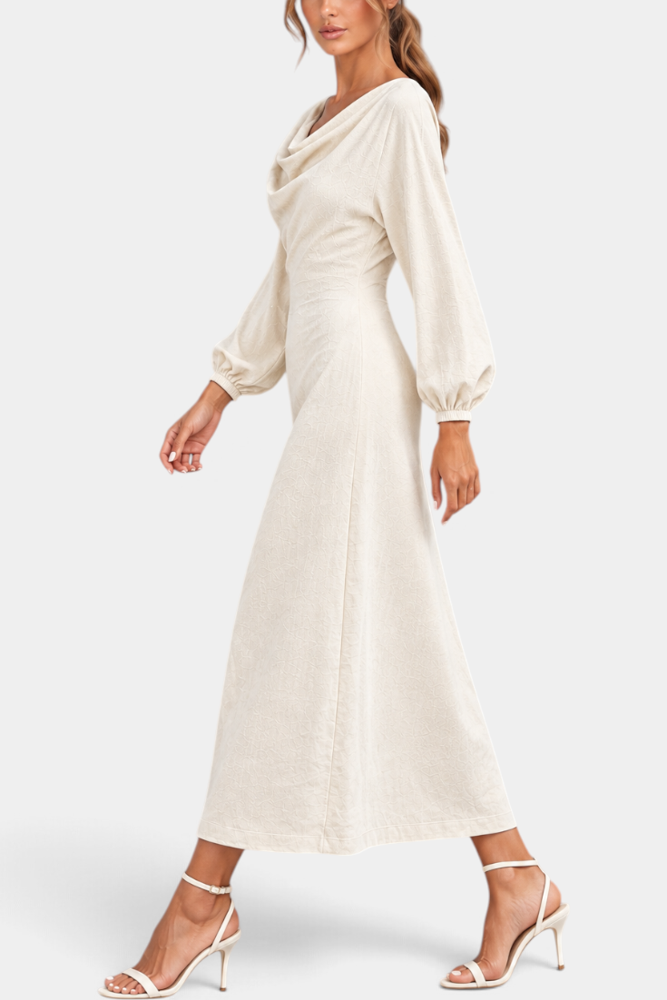 Mahaute Nicole long cream dress with draped cowl neck, balloon sleeves, and textured fabric on a walking model.