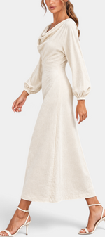 Mahaute Nicole long cream dress with draped cowl neck, balloon sleeves, and textured fabric on a walking model.