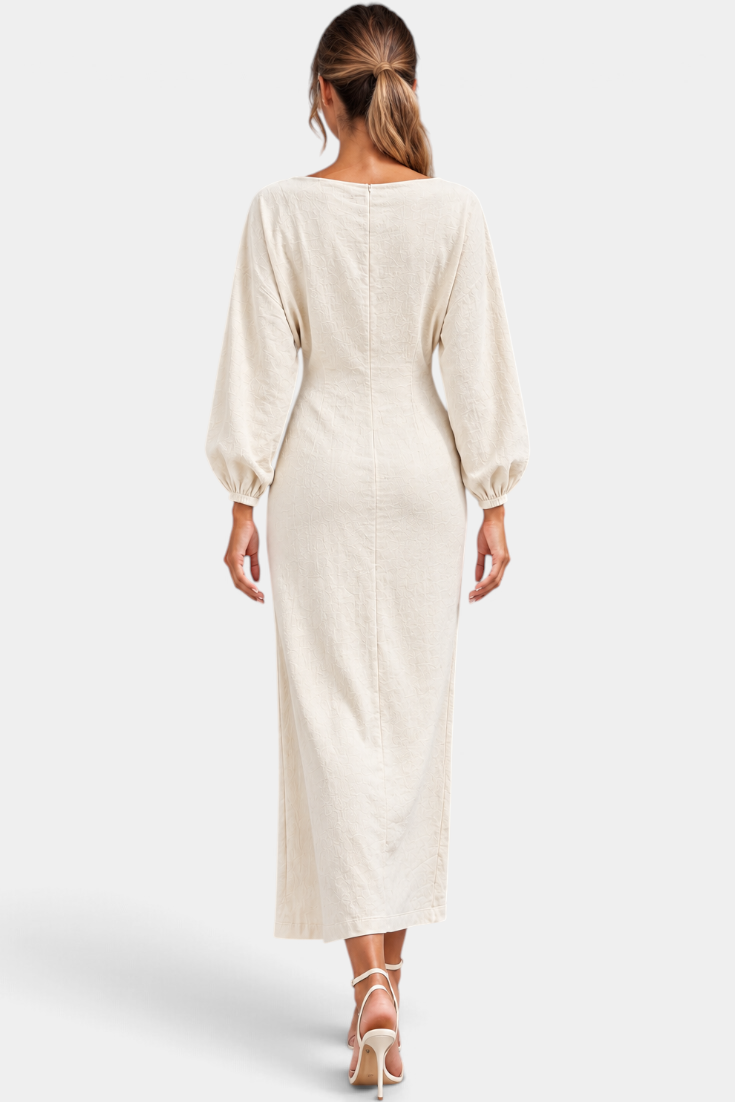 Back view of Mahaute Nicole long cream dress with balloon sleeves and fitted waist on a model with heels