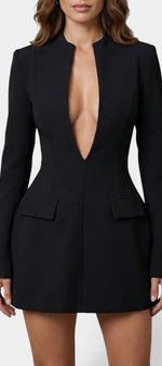 Robe courte noire Mahaute Nuria avec décolleté plongeant, manches longues et silhouette structurée, portée élégante et moderne.