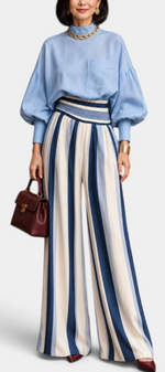 Mahaute Orlianne ensemble with blue puff-sleeve blouse and high-waisted wide-leg striped trousers.