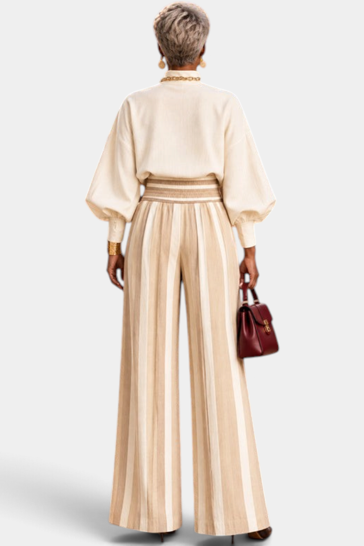 Back view of Mahaute Orlianne cream blouse with puff sleeves and beige striped wide-leg high-waisted trousers.