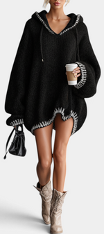 Mahaute Perdita black oversized knit sweater dress with a hood, balloon sleeves, and white contrast trim details.