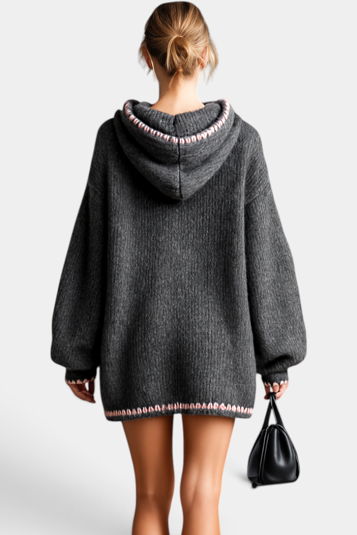 Mahaute Perdita grey oversized knit sweater dress with a hood, balloon sleeves, and pink contrast stitch detailing.