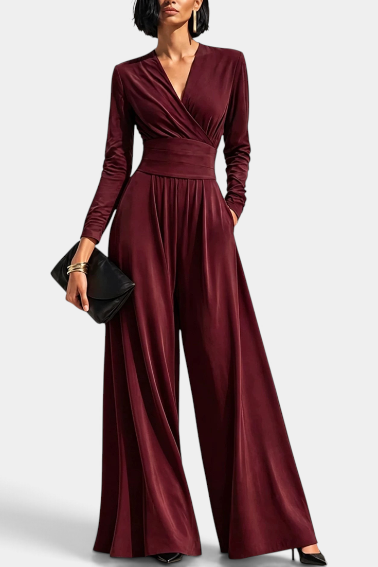 Mahaute Petronella burgundy long-sleeve jumpsuit with a wrap neckline, high waist, and wide-leg trousers.