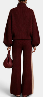 Back view of Mahaute Radostina ribbed knit set in burgundy with beige side stripes, zip jacket and wide-leg pants.