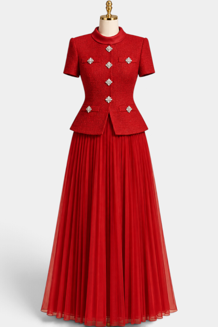 Mahaute red structured short-sleeve jacket with crystal jewel buttons paired with a long pleated skirt on a mannequin
