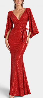 Mahaute red sequin evening gown featuring a deep V-neck, tie waist, and dramatic flared sleeves on a model