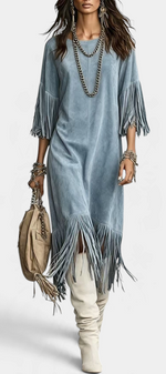 Mahaute Rozenn blue suede-effect midi dress with fringe sleeves and hem, worn with tall boots and layered necklaces.