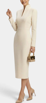 Mahaute Sandy cream midi dress with long sleeves, high slit neckline, and fitted silhouette on a model.