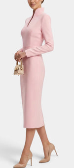 Mahaute Sandy light pink midi dress with a high slit collar and long sleeves worn by a model with nude heels.