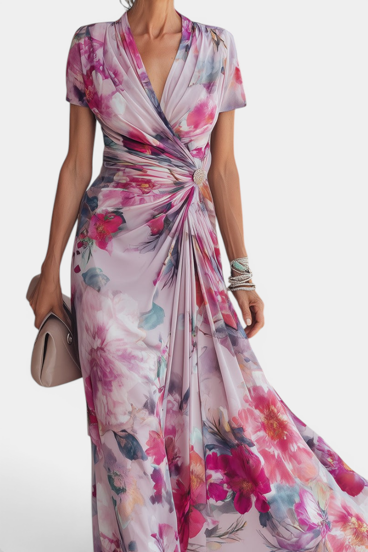 Mahaute Sanna long floral wrap dress with draped waist, jewel button detail, and watercolor print in pink and purple.