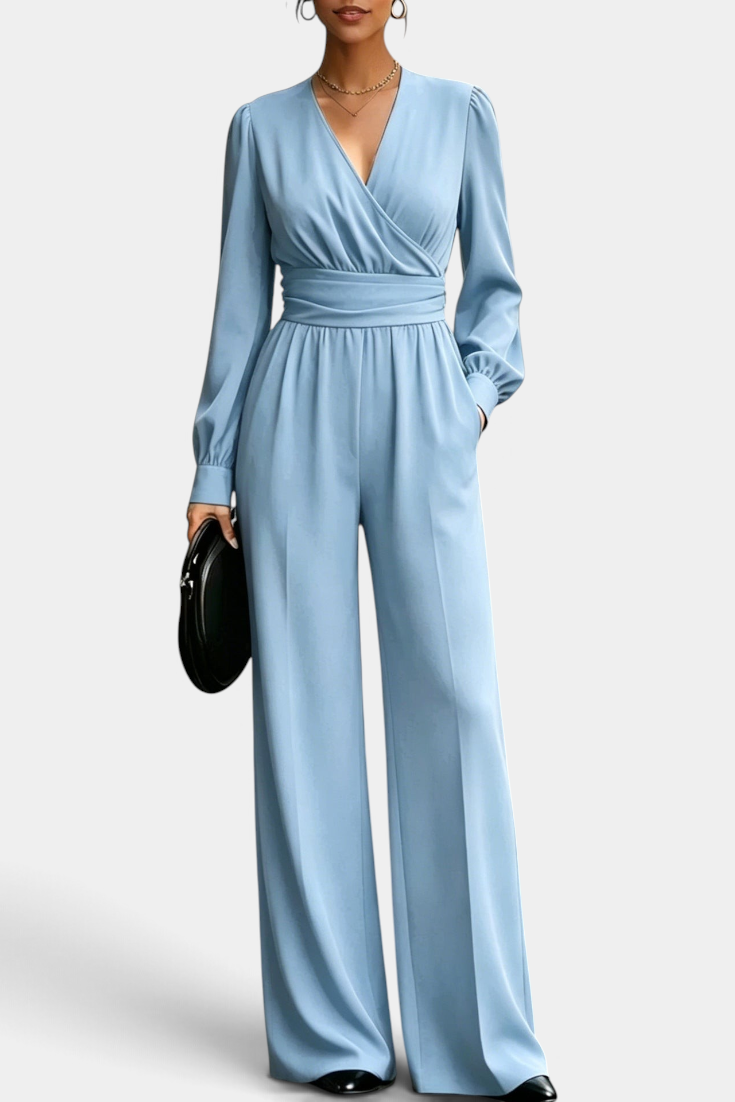 Mahaute Sophronia light blue long-sleeve jumpsuit with a wrap V-neck, draped waist, and wide-leg trousers.