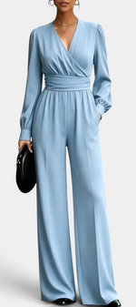 Mahaute Sophronia light blue long-sleeve jumpsuit with a wrap V-neck, draped waist, and wide-leg trousers.