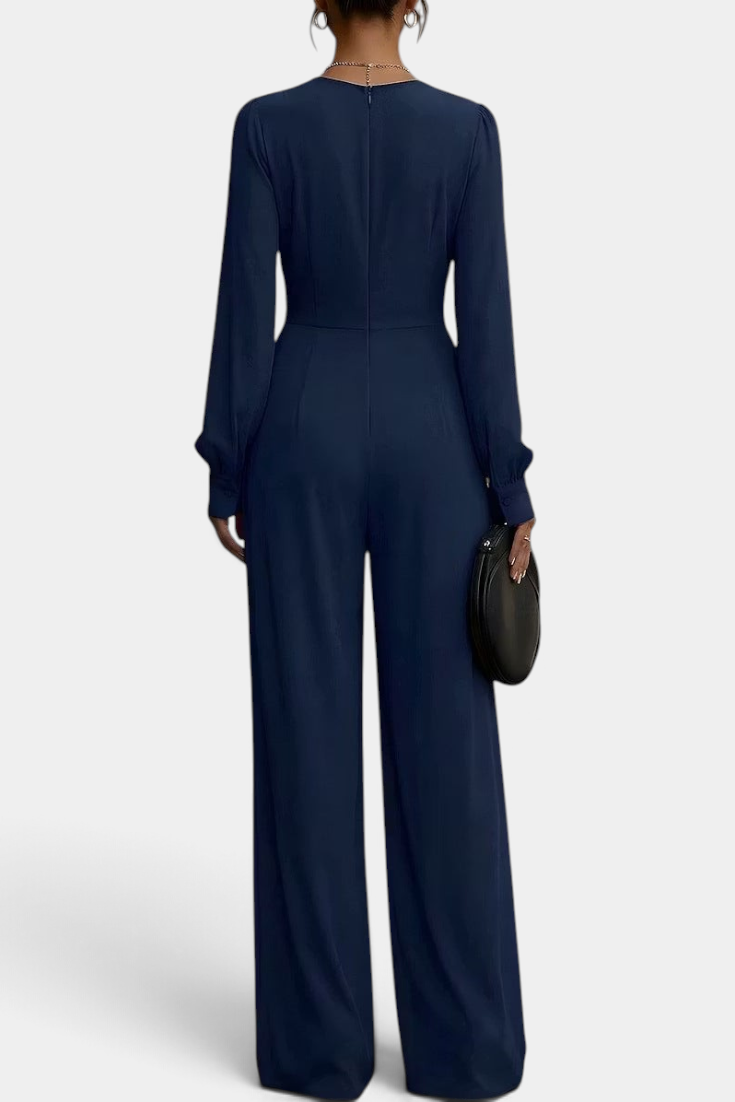 Back view of a Mahaute Sophronia navy blue long-sleeve wide-leg jumpsuit with a draped waist and elegant silhouette.