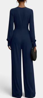 Back view of a Mahaute Sophronia navy blue long-sleeve wide-leg jumpsuit with a draped waist and elegant silhouette.