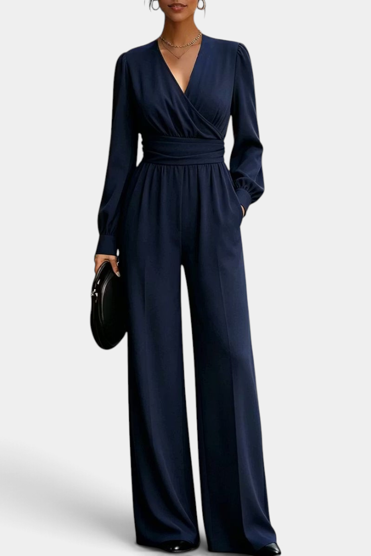 Mahaute Sophronia navy blue long-sleeve jumpsuit with a wrap V-neck, draped waist, and wide-leg trousers.