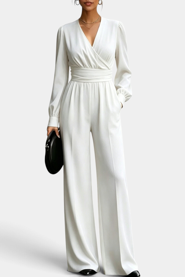 Mahaute Sophronia white long-sleeve jumpsuit with a wrap V-neck, draped waist, and wide-leg trousers.