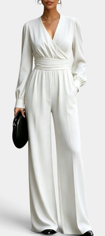 Mahaute Sophronia white long-sleeve jumpsuit with a wrap V-neck, draped waist, and wide-leg trousers.