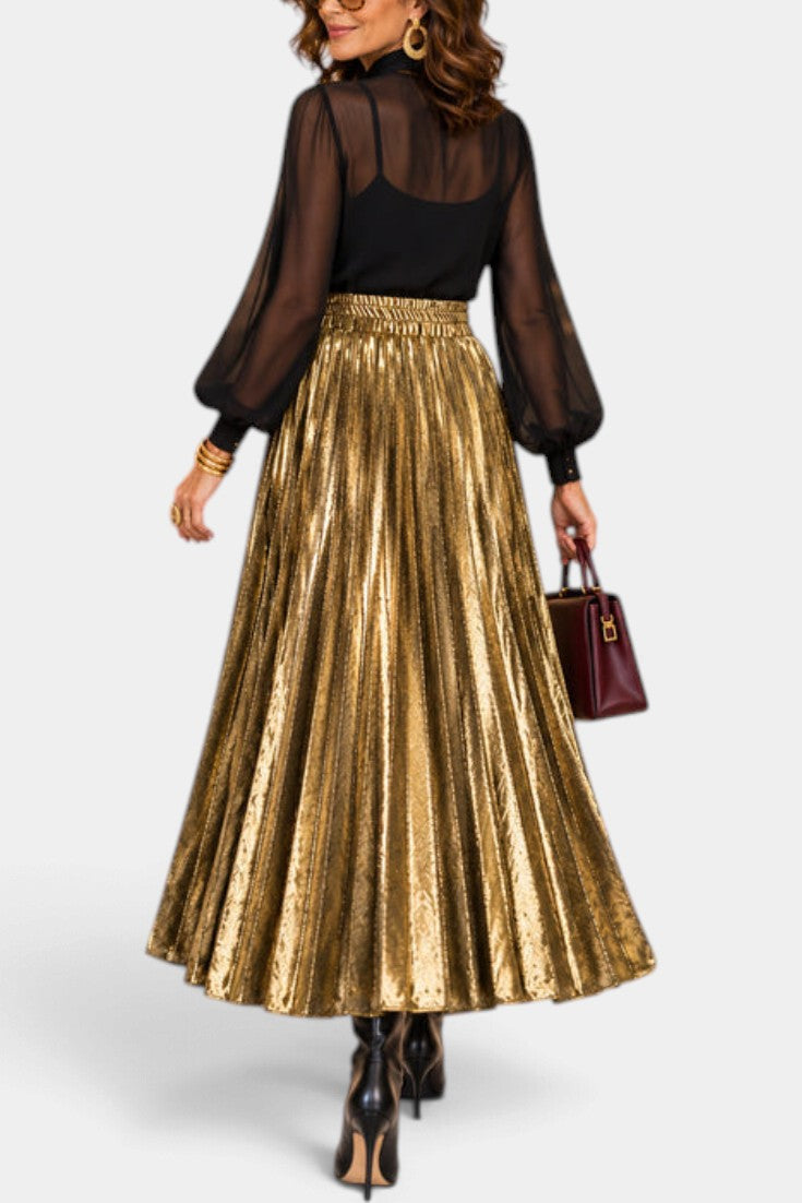 Mahaute Tegan high-waisted gold metallic pleated maxi skirt worn with a black blouse and dark handbag
