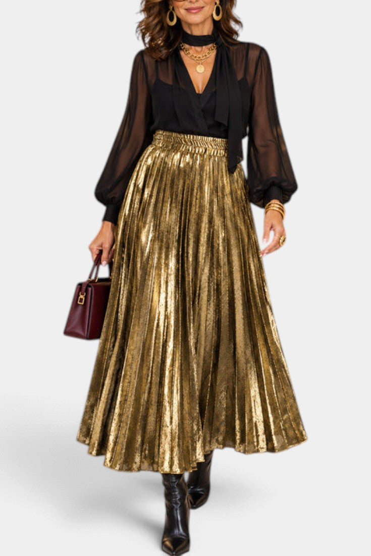 Mahaute Tegan high-waisted metallic gold pleated maxi skirt worn with a black blouse and boots