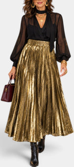Mahaute Tegan high-waisted metallic gold pleated maxi skirt worn with a black blouse and boots