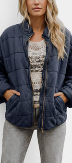 Veste courte matelassée Mahaute Tessel en bleu marine, avec col montant et fermeture zippée, idéale pour un look élégant et chaud.