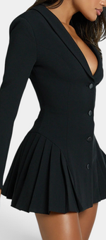 Mahaute Thelma black blazer dress with deep V-neck, cinched waist, and pleated skirt on a model