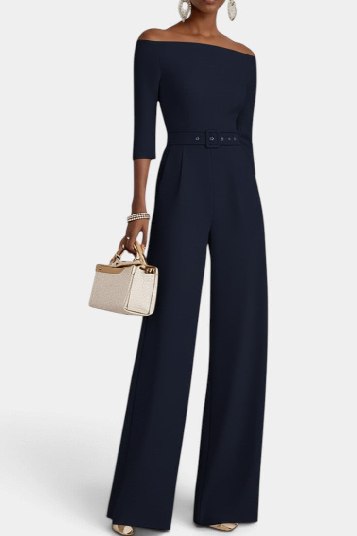 Mahaute Tisdale navy blue off-shoulder jumpsuit with three-quarter sleeves, belted waist, and wide-leg trousers.
