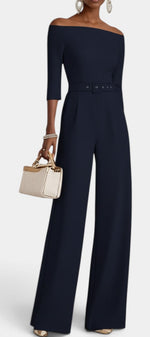 Mahaute Tisdale navy blue off-shoulder jumpsuit with three-quarter sleeves, belted waist, and wide-leg trousers.
