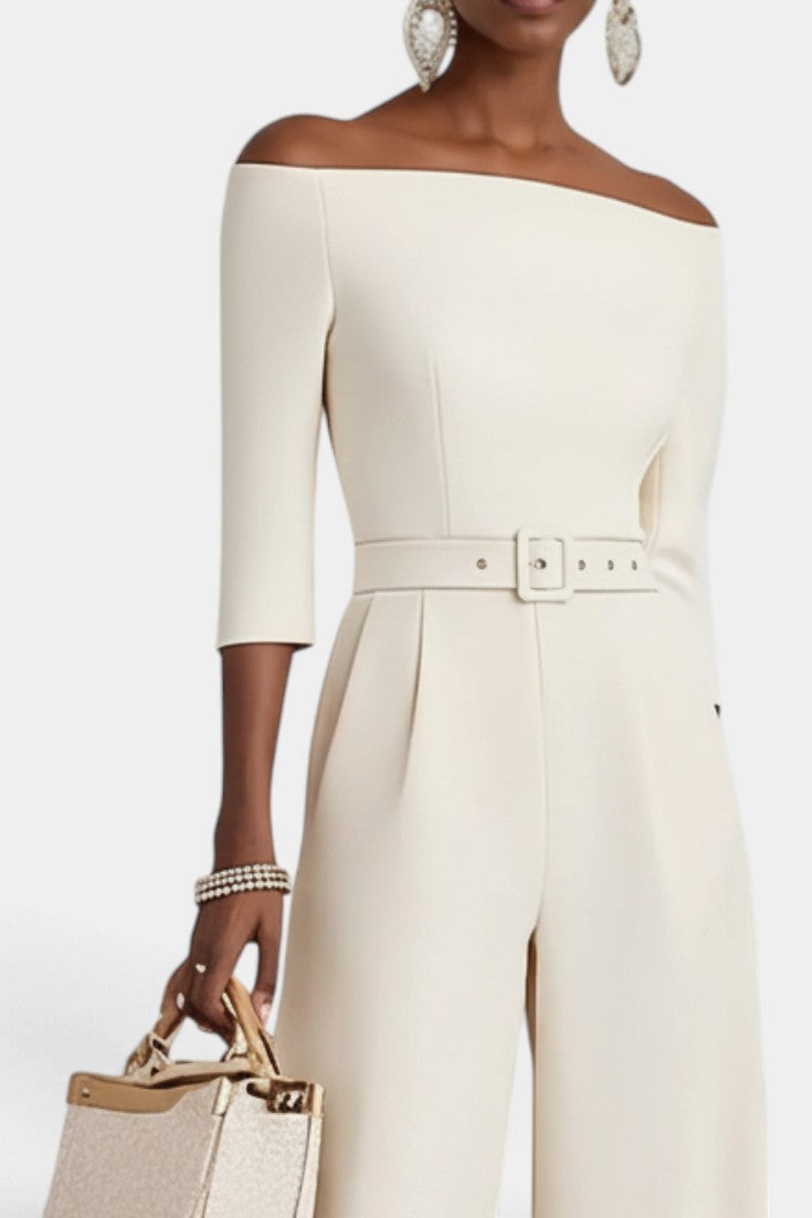 Mahaute Tisdale off-shoulder cream jumpsuit with three-quarter sleeves, belted waist, and wide-leg trousers.