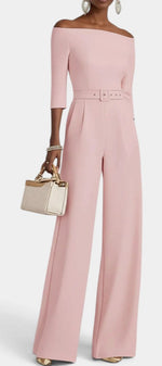 Mahaute Tisdale pale pink off-the-shoulder jumpsuit with a belted waist, three-quarter sleeves, and wide-leg trousers.