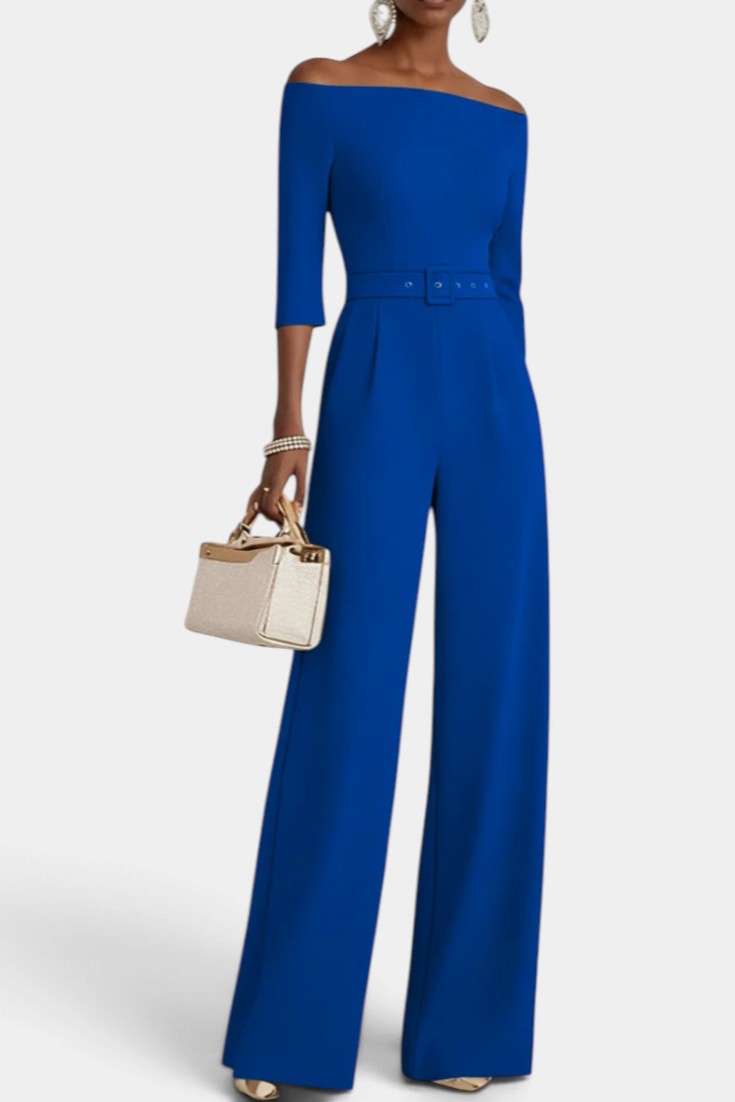 Mahaute Tisdale royal blue off-shoulder jumpsuit with a belted waist, three-quarter sleeves, and wide-leg trousers.
