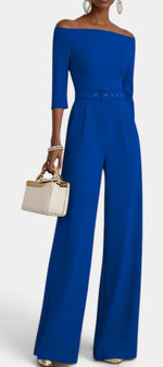 Mahaute Tisdale royal blue off-shoulder jumpsuit with a belted waist, three-quarter sleeves, and wide-leg trousers.
