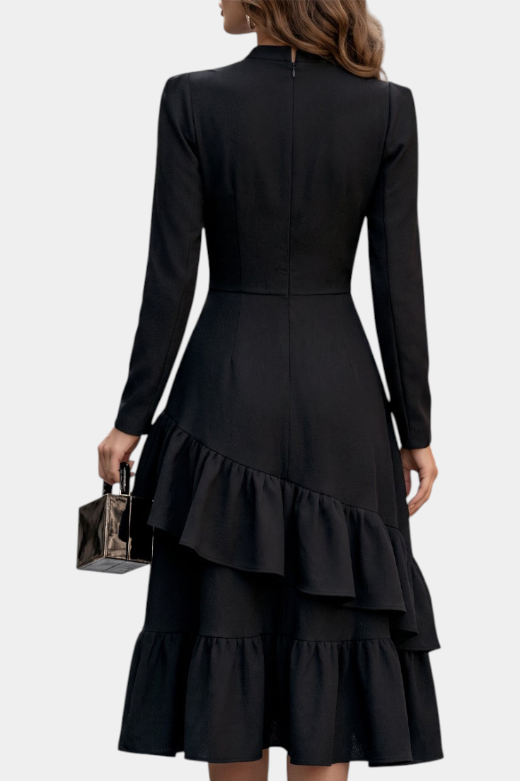 Mahaute Velislava black midi dress with long sleeves, cinched waist, and asymmetrical ruffled hem, back view.
