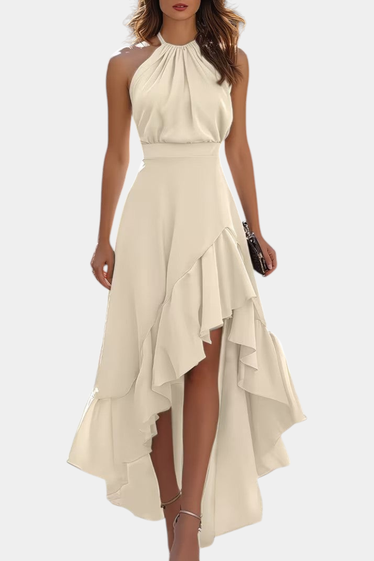 Mahaute Verity beige asymmetrical maxi dress with a pleated halter neckline, fitted waist, and flowing ruffled skirt.