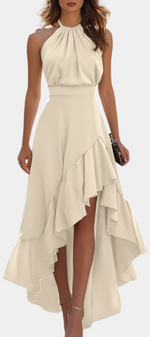 Mahaute Verity beige asymmetrical maxi dress with a pleated halter neckline, fitted waist, and flowing ruffled skirt.