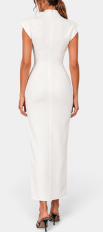 Back view of a model wearing a Mahaute white long fitted dress with a high collar and structured shoulders.